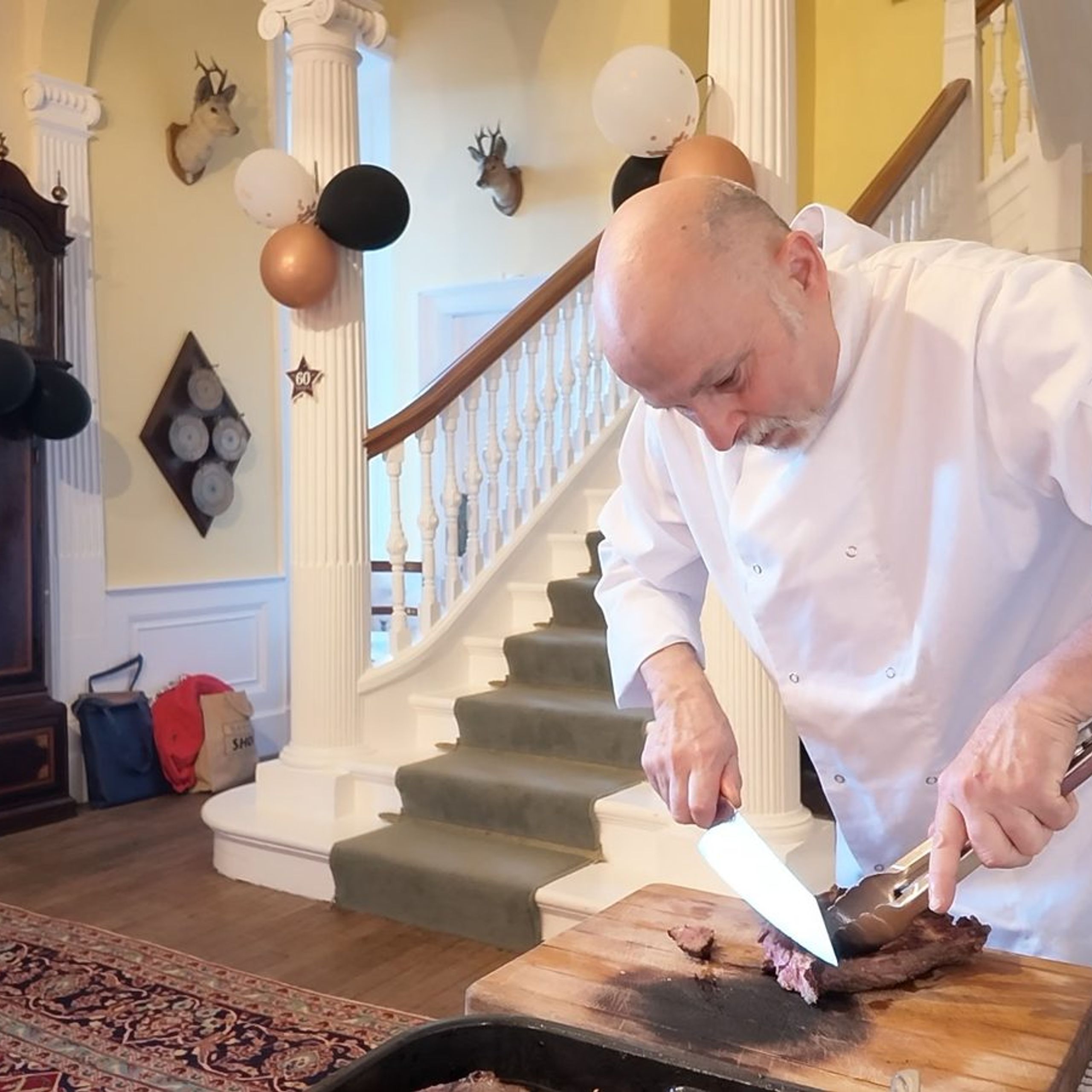 Private chef Giuseppe Manzoli carving roast beef in the hallway at Burgie House, Forres