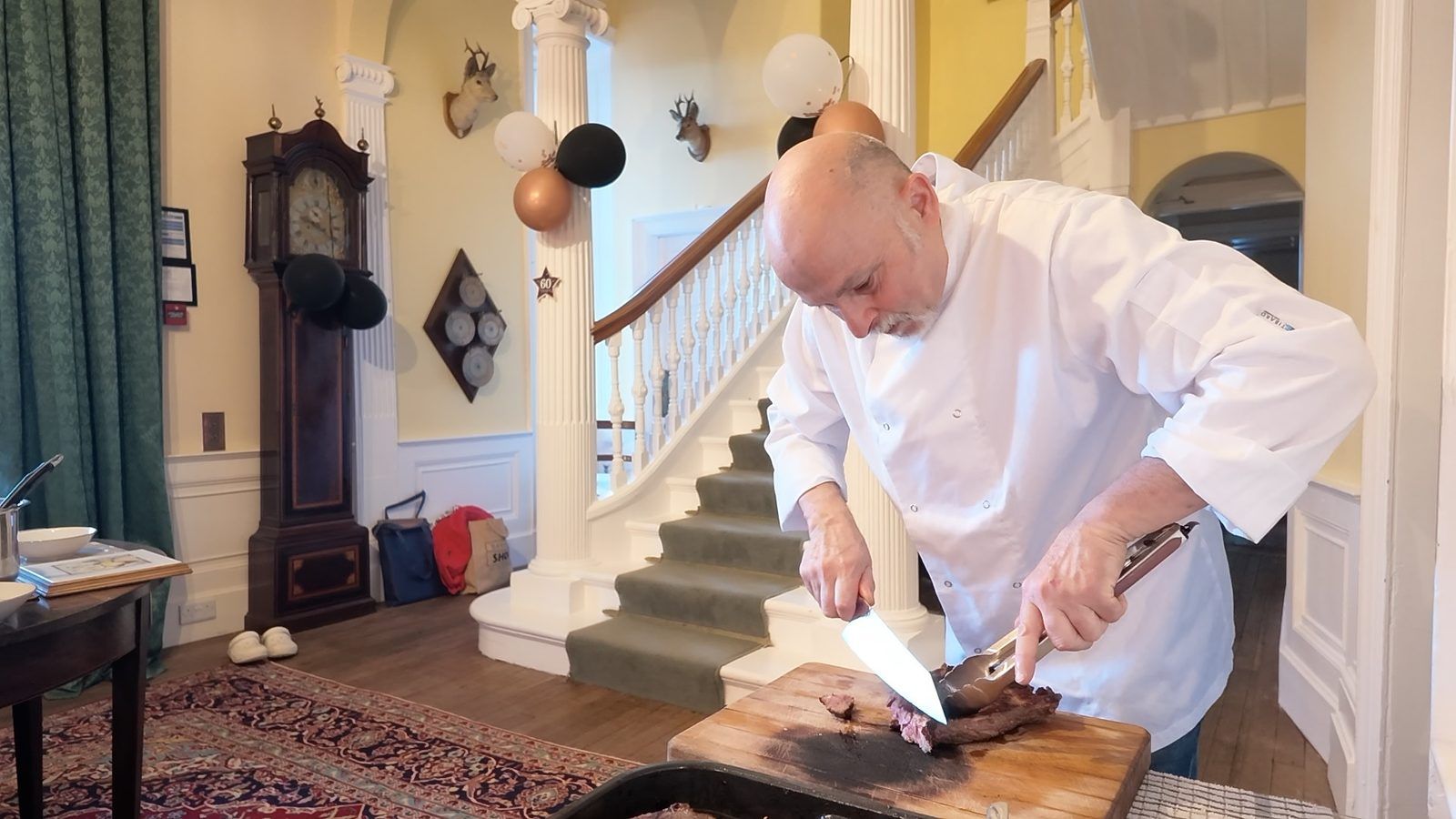 Private chef Giuseppe Manzoli carving roast beef in the hallway at Burgie House, Forres