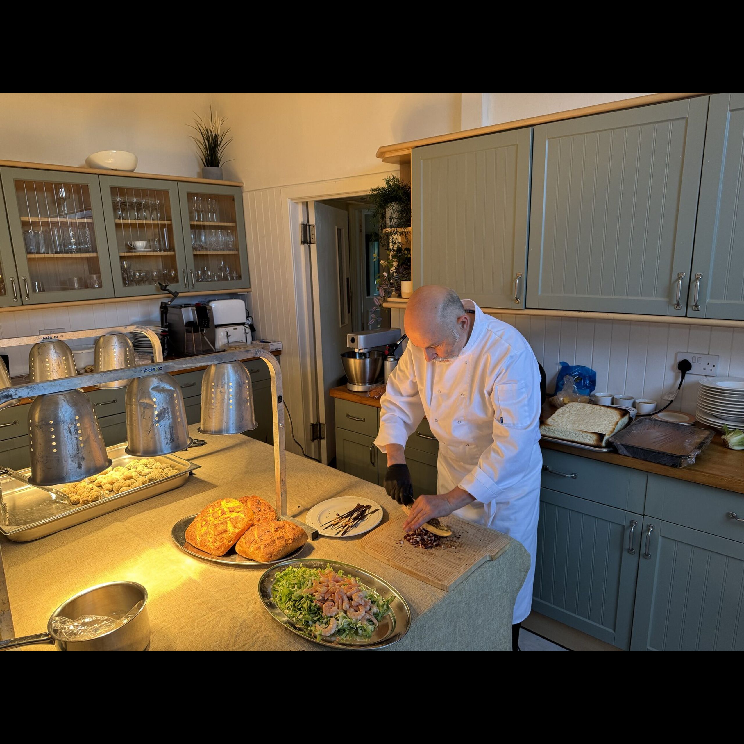 Giuseppe Manzoli preparing canapés and fresh bread in the Beechwood House kitchen