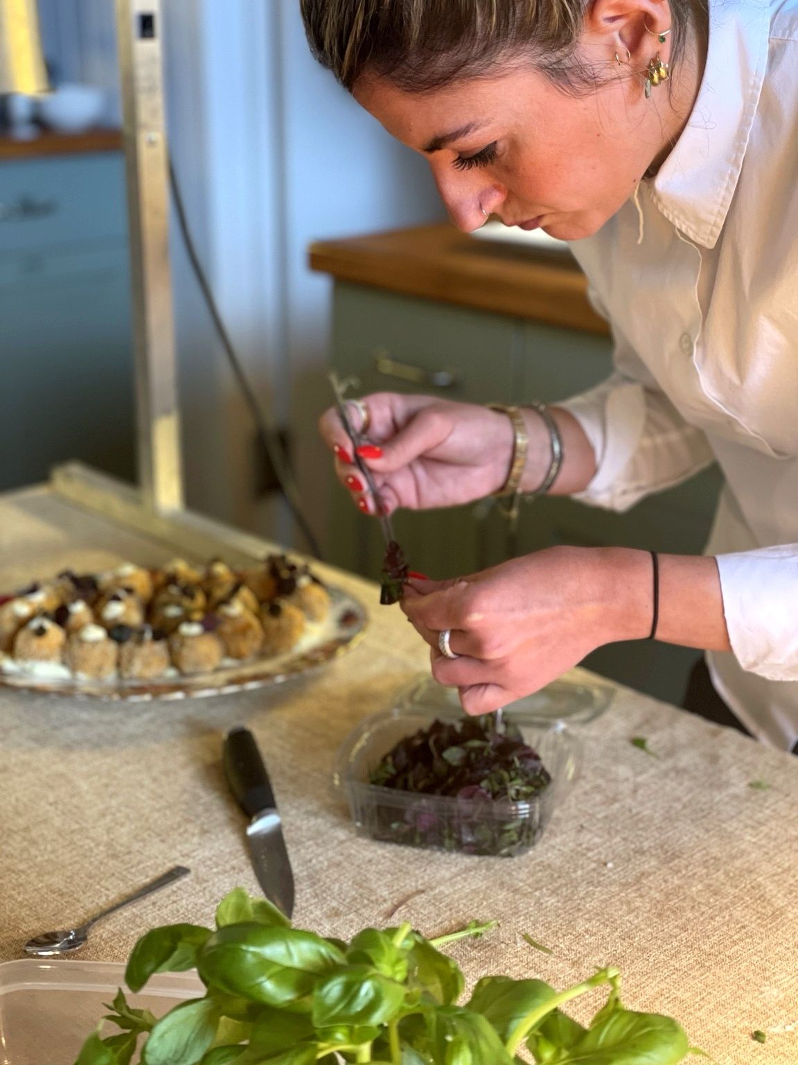 A member of Giuseppe Manzoli's team plating arancini canapés in the kitchen at a wedding at Beechwood House, Moffat — July 2024