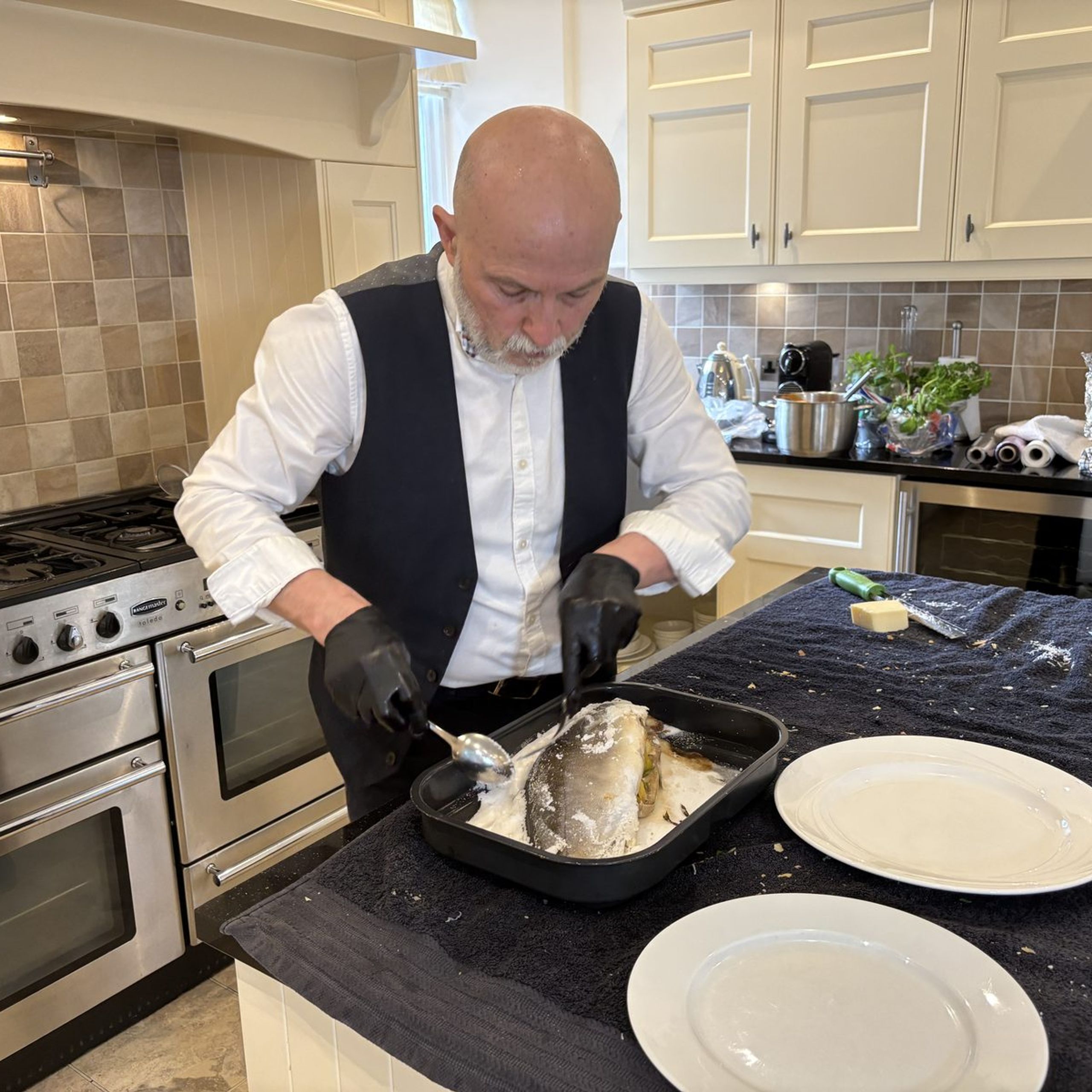 Giuseppe Manzoli opening a salt-baked whole fish in a Scottish kitchen
