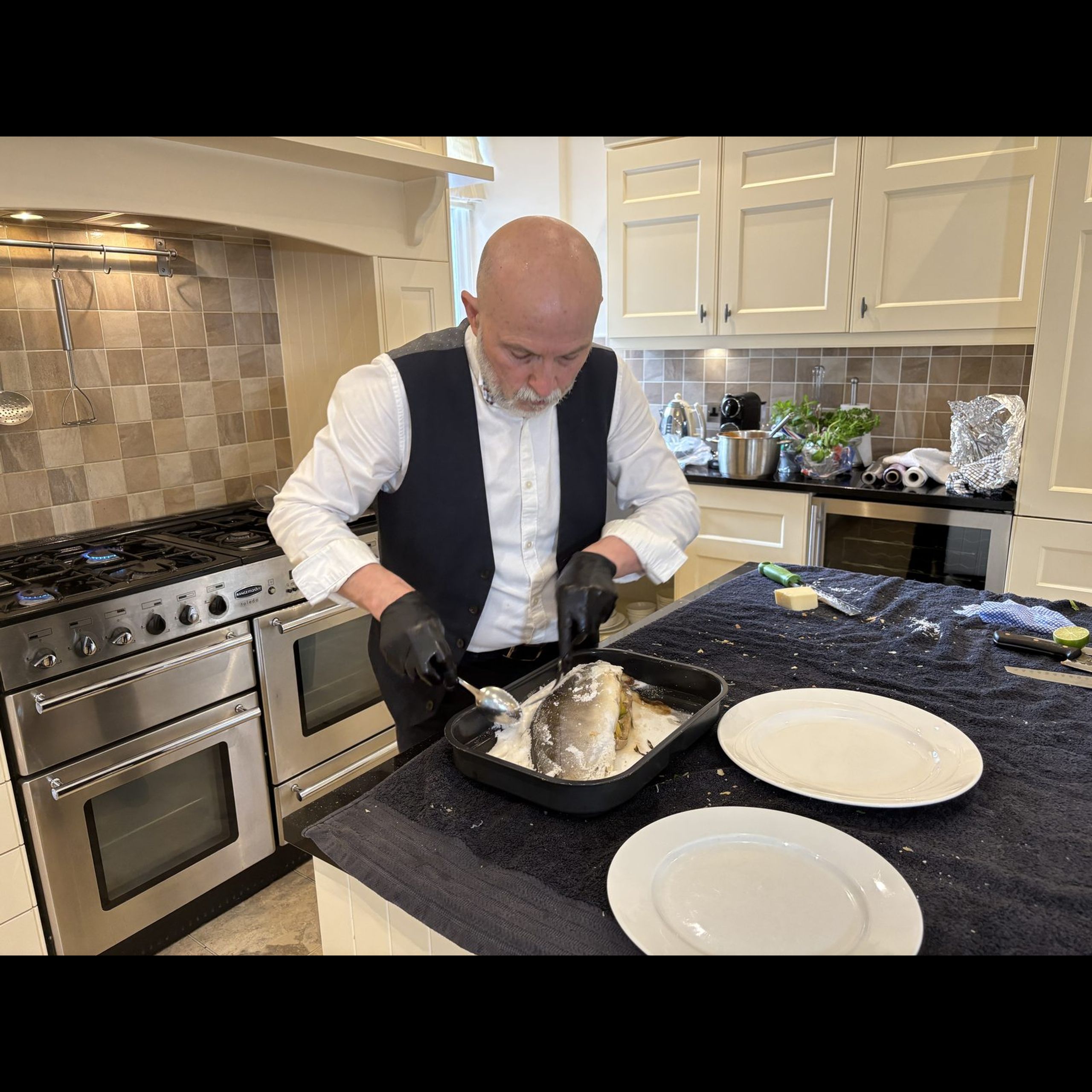 Giuseppe Manzoli opening a salt-baked whole fish in a Scottish kitchen