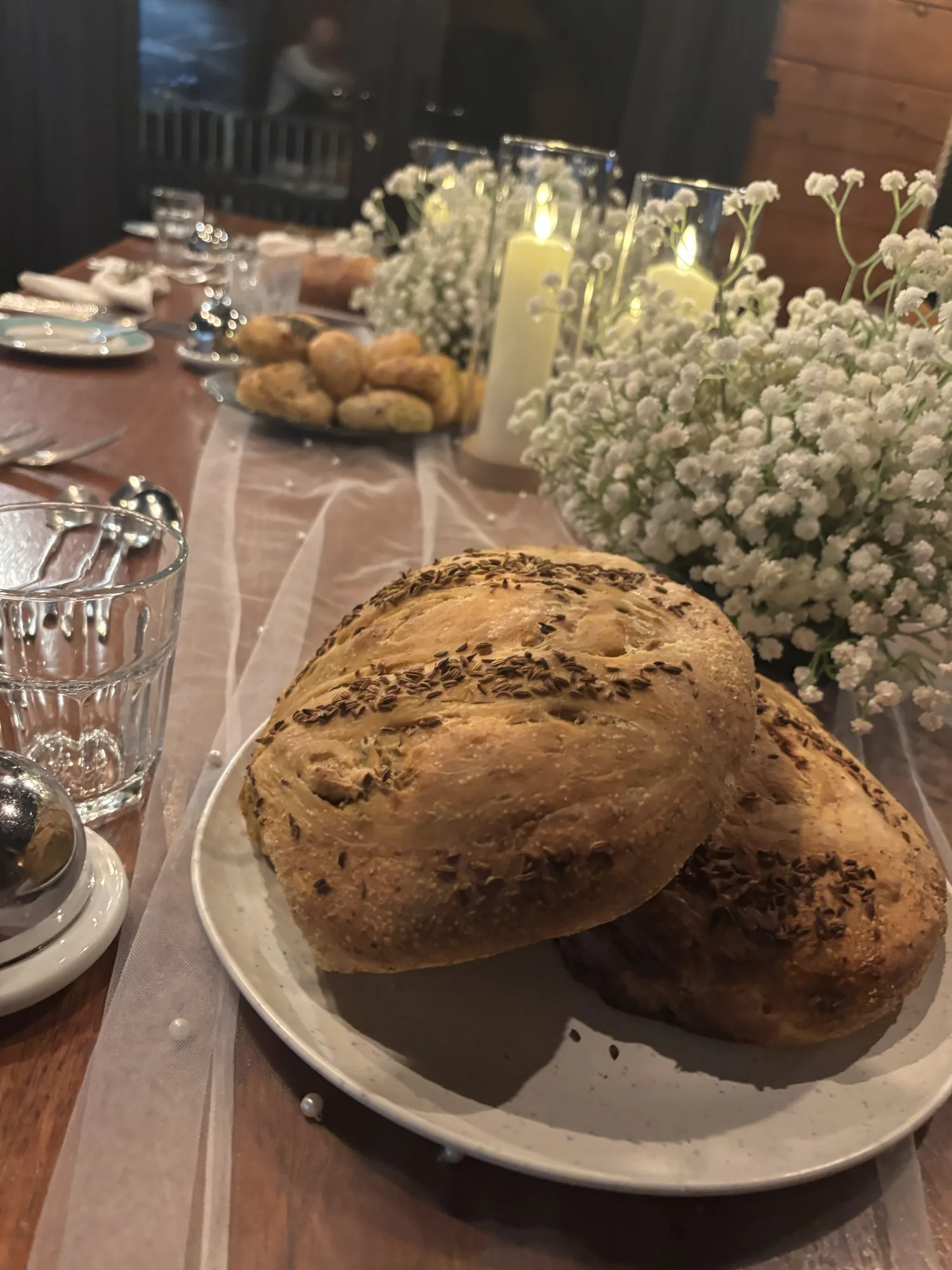 Homemade seeded bread on a candlelit pre-wedding dinner table at Loch Ness