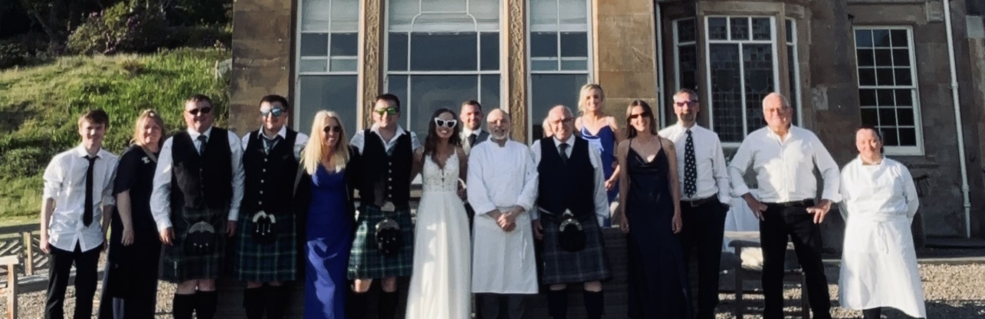 Giuseppe Manzoli in chef whites with a wedding party of 15 guests outside a country house in Tarbert, Argyll.