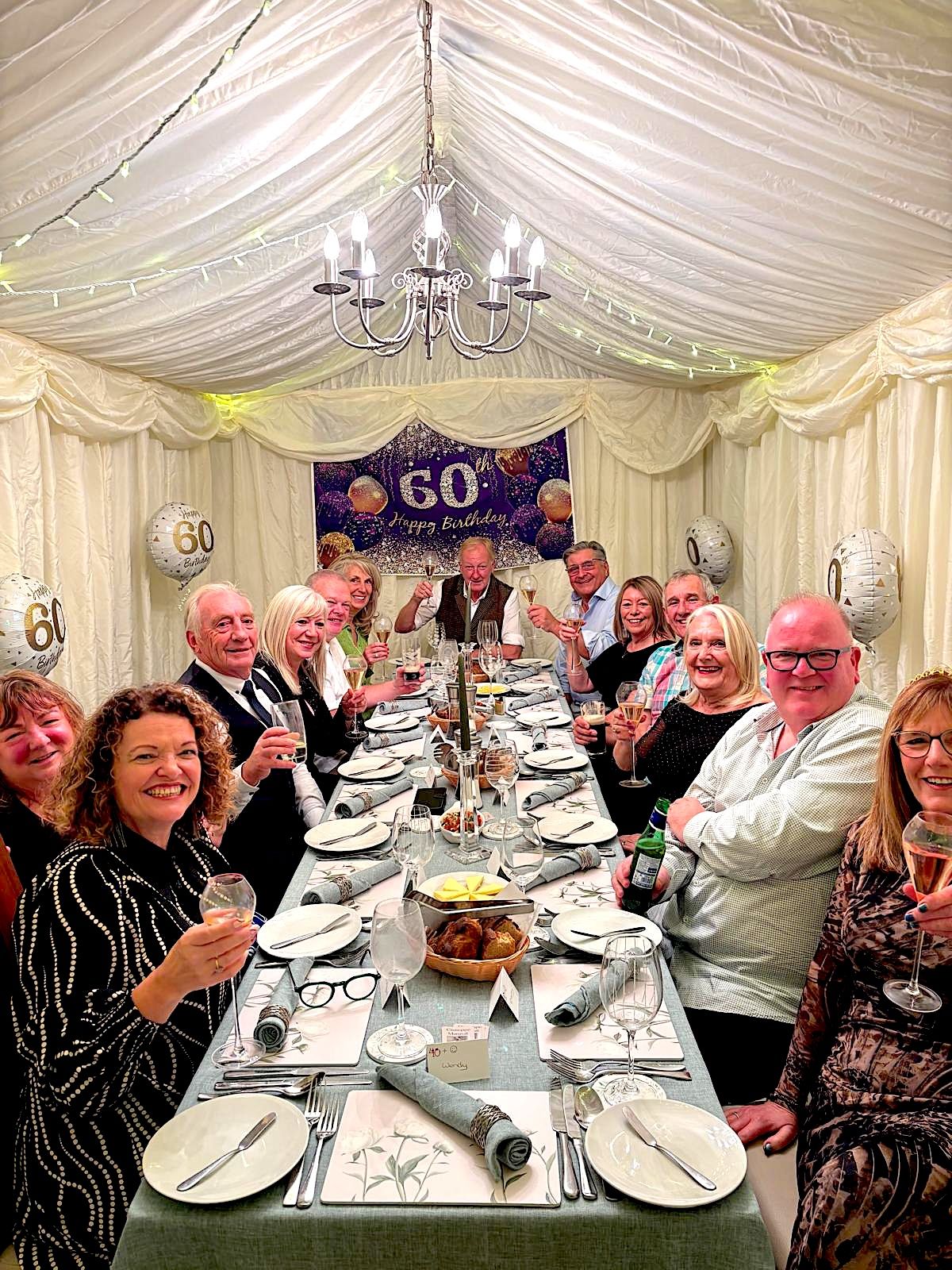 A 60th birthday dinner for fourteen guests in a marquee — long table set with restaurant-style plating, candles and fresh bread — Italian private chef Giuseppe Manzoli in West Fife