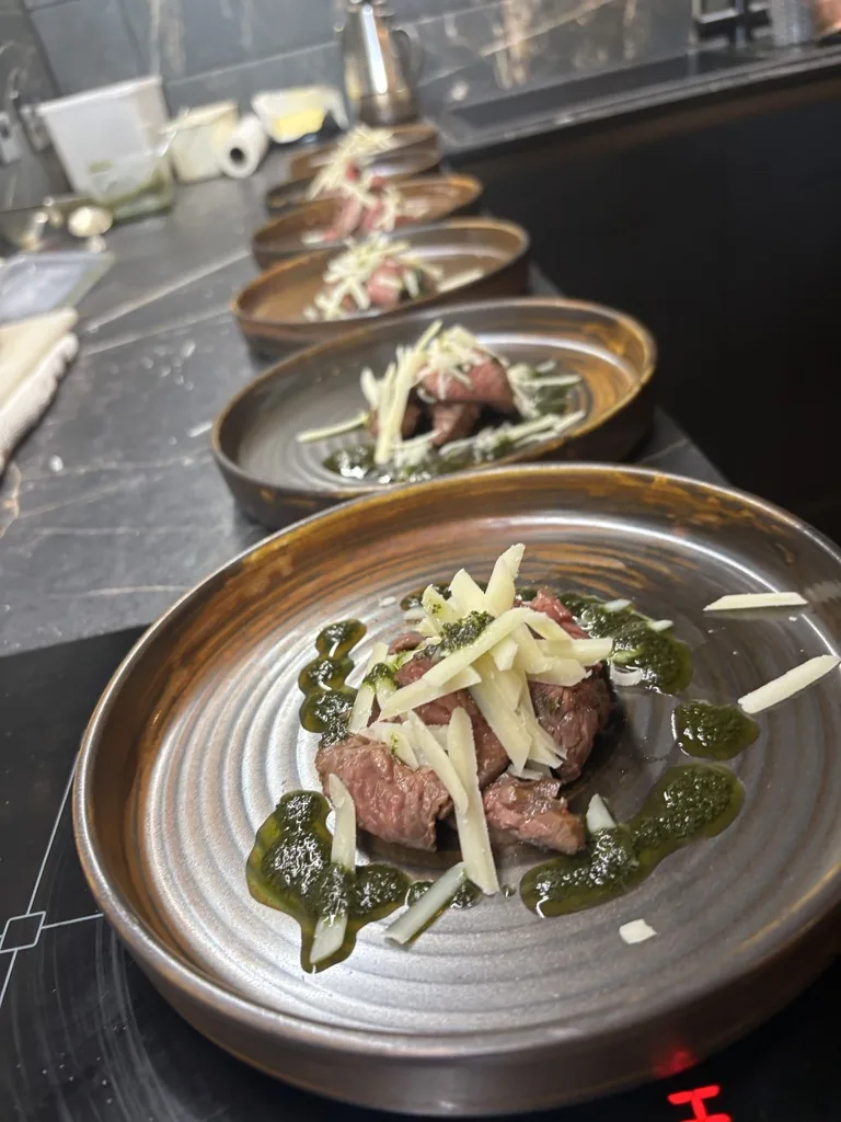 Tagliata di Manzo with Parmesan and herb dressing plated by a private chef at Loch Ness